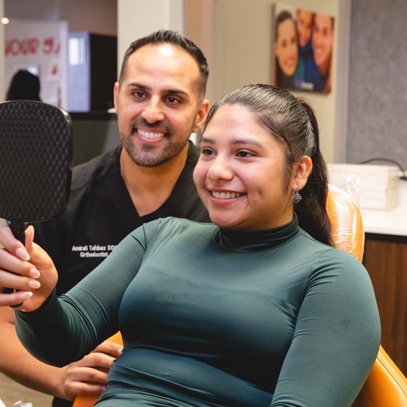 Orthodontist in Austin smiling with patient reviewing progress in orthodontic treatment at Luv Braces, showcasing a positive experience.