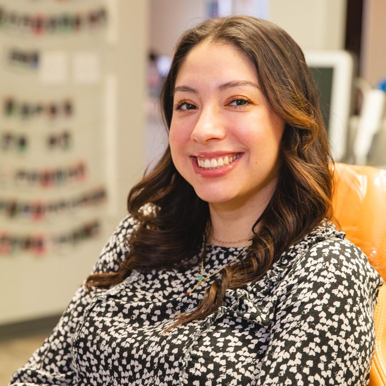 Smiling young woman in orthodontic office, showcasing a healthy smile relevant to Austin orthodontics and Invisalign treatments.